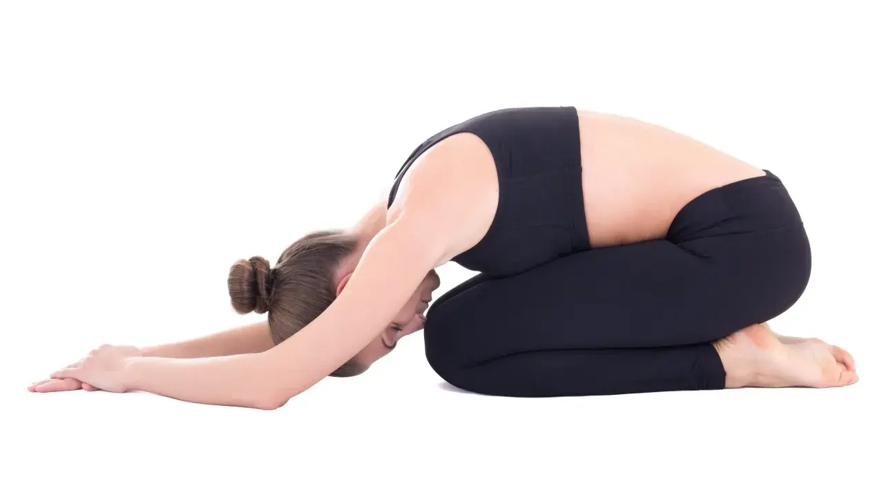 Frau in Kindhaltung, die bei Hexenschuss wie schlafen hilft. Entspannende Yoga-Pose für den Rücken.