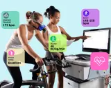 Frau auf Ergometer mit Maske, Trainer überwacht Werte wie VO2max (48 ml/kg/min), anaeroben Schwellenwert (172 bpm) und Fitness-Rating (Excellent).