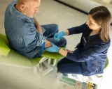 Arzt nimmt Blut ab, um das biologische Alter zu bestimmen. Die Ergebnisse werden in einer biologisches alter tabelle ausgewertet.