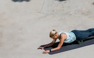 Frau rollt mit Foam Roller ihre Beine nach dem Laufen aus.