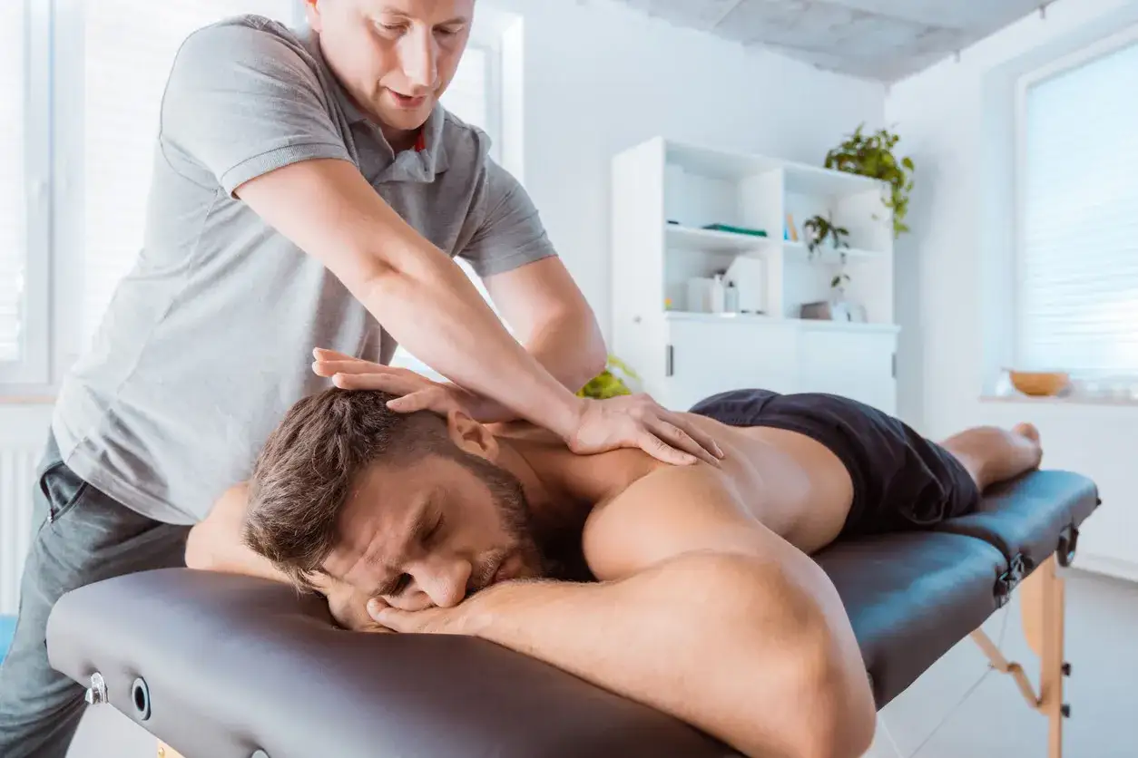 Ein Mann erh&auml;lt eine Sportmassage zur Linderung von Muskelverspannungen. Dies ist ein Beispiel daf&uuml;r, was eine Sportmassage ist: gezielte Behandlung zur Regeneration.