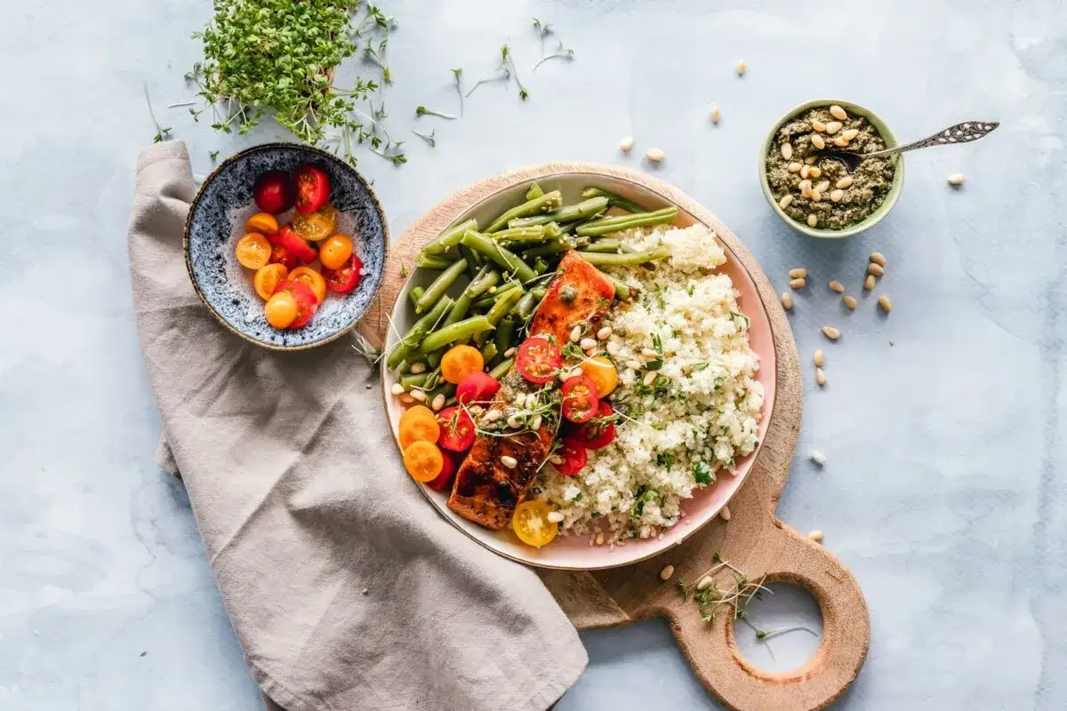 Gesunder Lachs mit Quinoa, grünen Bohnen und Tomaten. Ein Gericht, das sich gut in TCM Rezepte integrieren lässt.